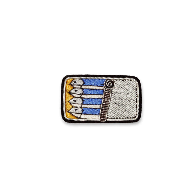 Macon & Lesquoy sardine tin lapel pin hand-embroidered in gold, blue and silver thread, photographed on a plain white background