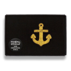 The gold anchor brooch presented inside the maker's black card and velvet gift box