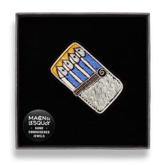 The sardine tin brooch presented inside the maker's black card and velvet gift box
