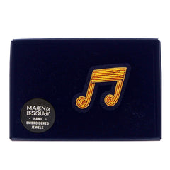 The musical note brooch presented inside the maker's navy card and velvet gift box