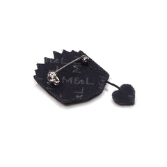 Reverse of the open book brooch showing the pin fastening and the heart charm on its short chain