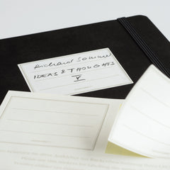 Black LEUCHTTURM1917 notebook with the supplied archiving stickers laid on the cover for labelling