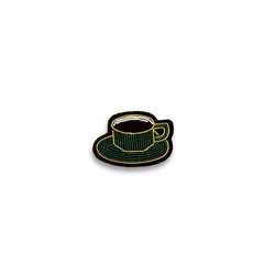 Macon & Lesquoy cup of coffee lapel pin hand-embroidered in green and gold thread, photographed on a plain white background